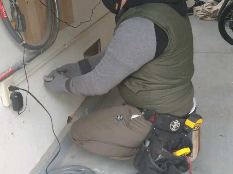 Electrician performing outlet wiring in a Camilla garage